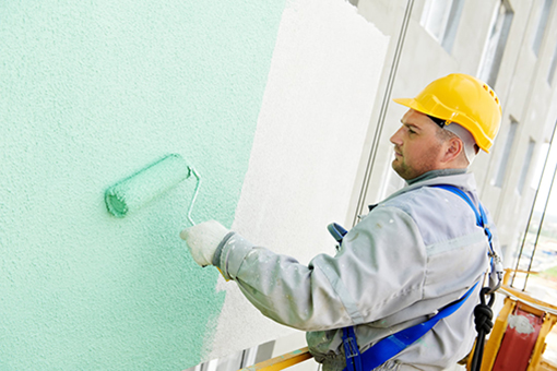 Professional Painter Using a Roller to Coat a House in Valrico FL