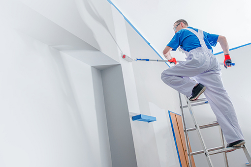 Professional House Painter Standing on a Ladder to Paint Harbour Island House