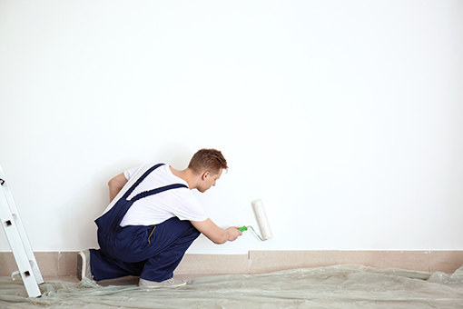 Professional House Painter Using a Rollerbrush To Paint Downtown Tampa Airbnb