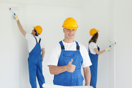 Two Beach Park House Painters Working in the Background and One Giving a Thumbs Up