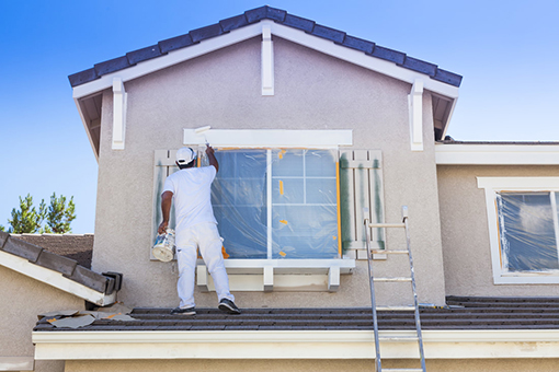 Professional House Painter in Wellswood FL On the Roof To Paint Exterior of Attic